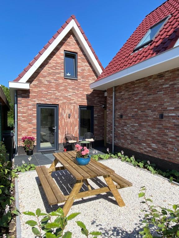 una mesa de picnic frente a una casa de ladrillo en Vakantiewoning Westkaap, en Westkapelle