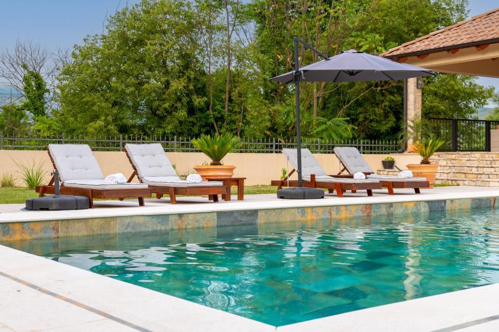 モスタルにあるVilla Ivanaのラウンジチェア2脚とパラソル付きのプールが備わります。