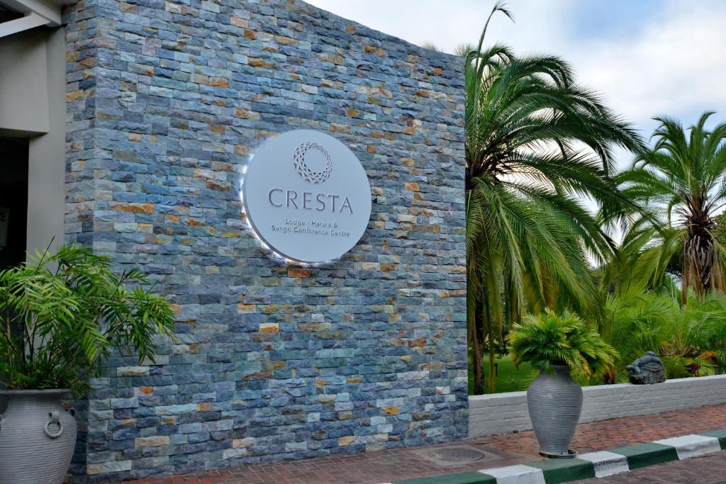 un cartel en el costado de un edificio de ladrillo en Cresta Lodge Harare, en Harare