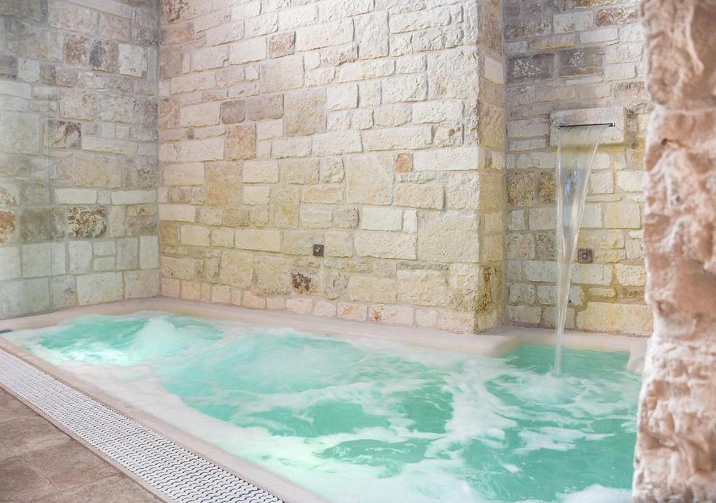 a jacuzzi tub with a water fountain at Trulli e Puglia Luxury Suite in Alberobello