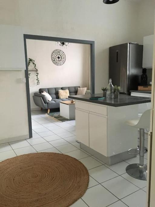 une cuisine et un salon avec un canapé dans l'établissement Jolie maison de ville au cœur de Pomerols, à Pomérols