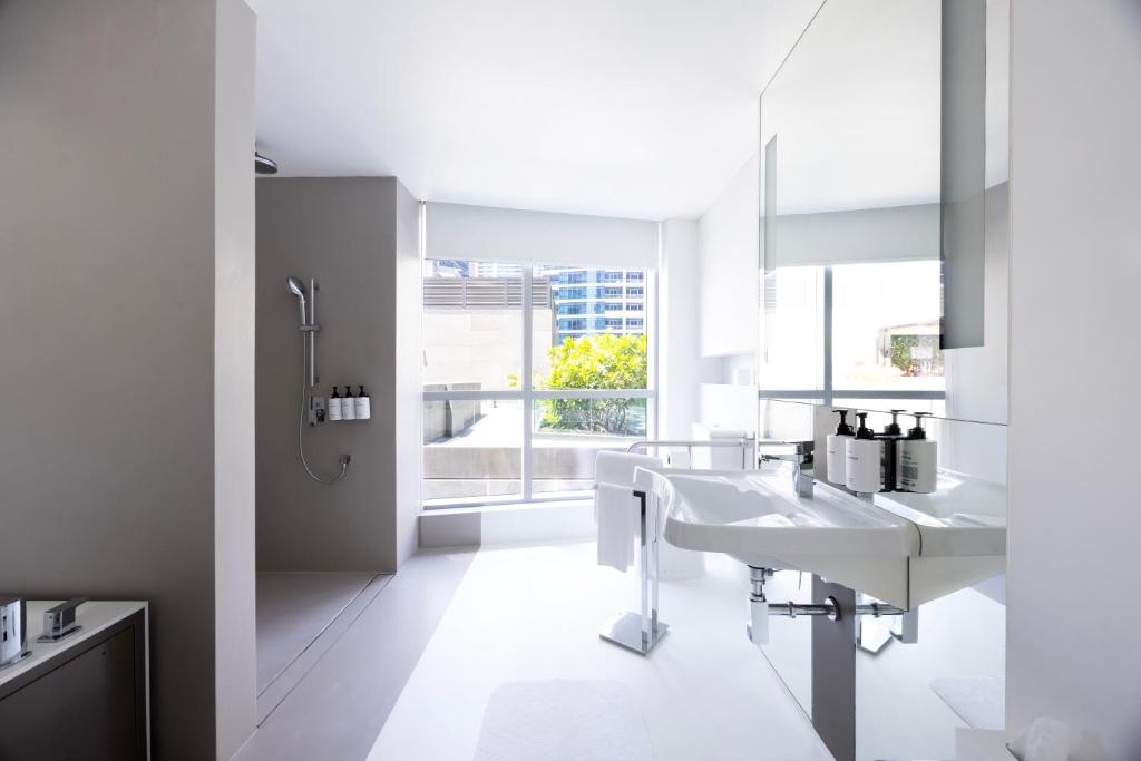 a white bathroom with two sinks and a shower at InterContinental Dubai Marina by IHG in Dubai