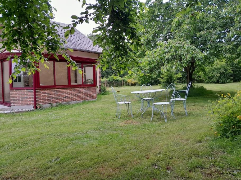 Breteuil-sur-ItonにあるSéjour ressourçant au coin des Amarantesの家の隣の庭のテーブルと椅子