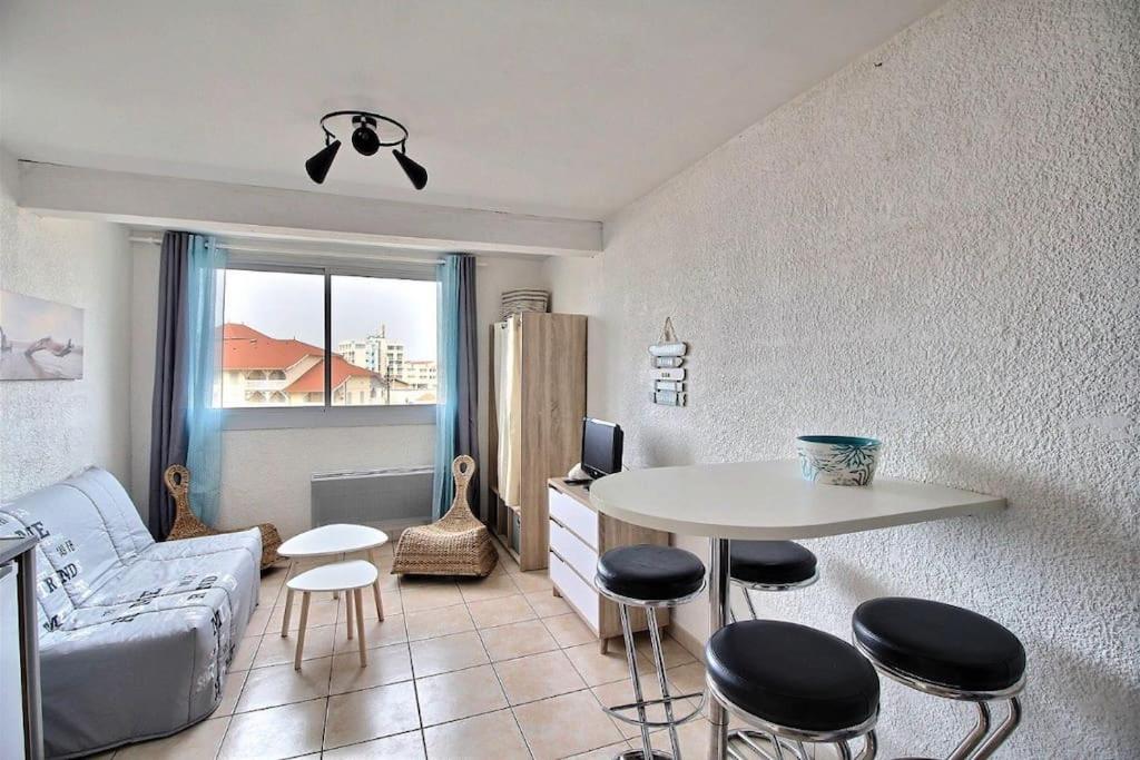 un salon avec un canapé, une table et des chaises dans l'établissement Studio MIMIZAN à 150m plage place du marché mimizan, à Mimizan