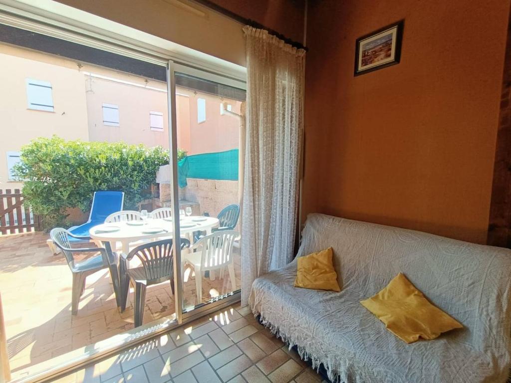 a bedroom with a bed and a balcony with a table at Maison à 150 m Plage 6LT221 in Saint Pierre La Mer