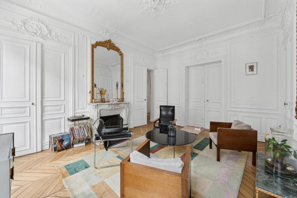 - un salon avec une table et un miroir dans l'établissement Veeve - Subtly Vintage, à Paris