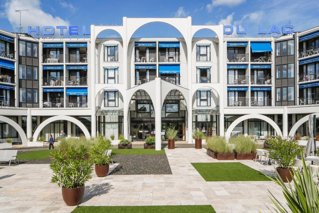 an apartment building with a courtyard in front of it at Brit Hotel du Lac in Saint-Paul-lès-Dax