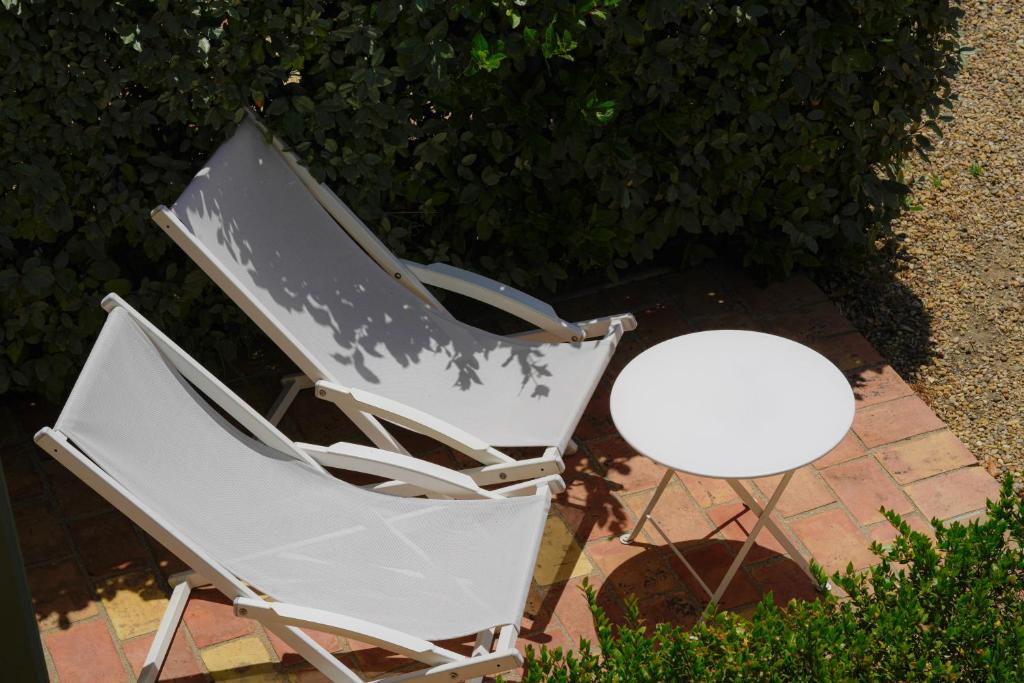 two white chairs and a white table on a patio at Hôtel La Figuière in Saint-Tropez