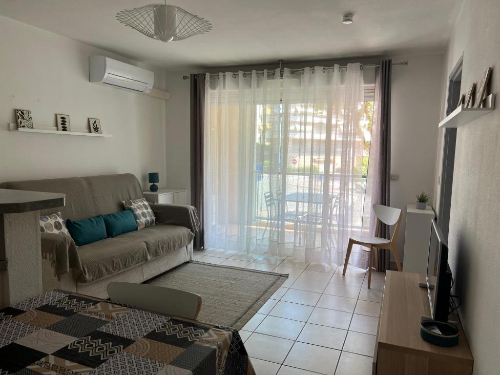 un salon avec un canapé et une grande fenêtre dans l'établissement Confort, à Menton