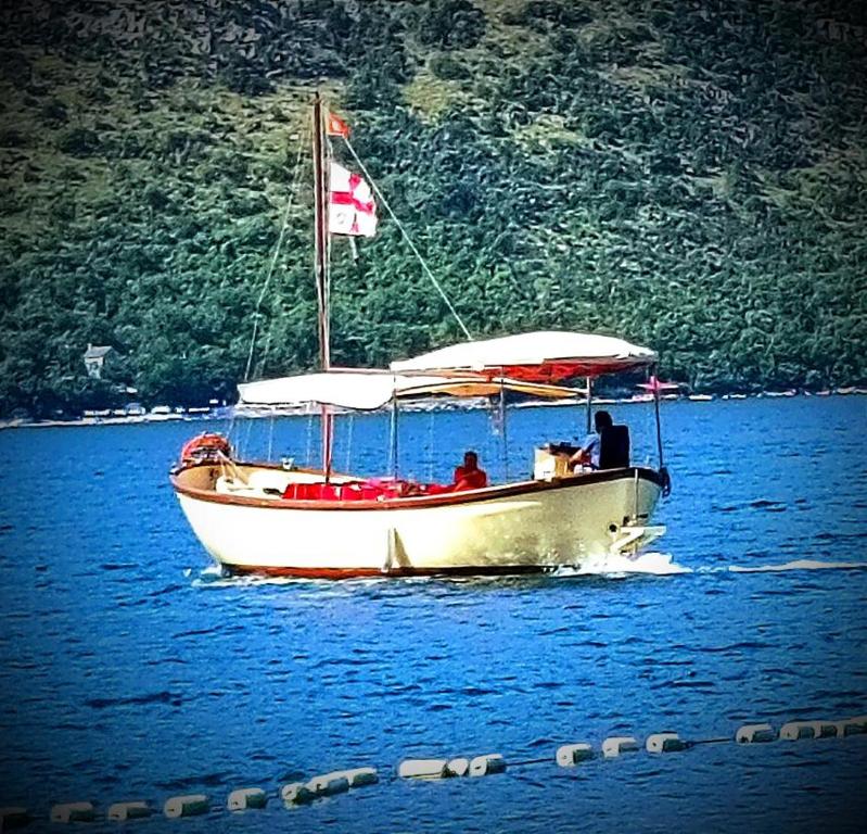 a white boat with a canadian flag on the water at Jadranka Boat in Tivat