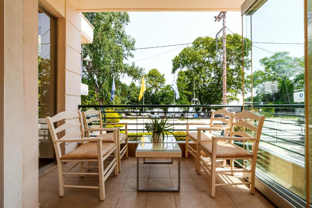 a balcony with chairs and a table and a window at Stefanidis Platani Beach in Stavros