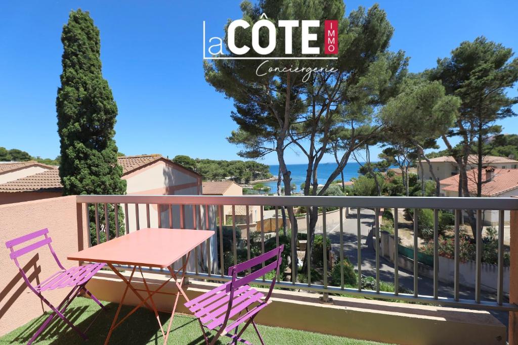 d'une terrasse avec des chaises violettes et une table sur un balcon. dans l'établissement la daurade, à Carry-le-Rouet