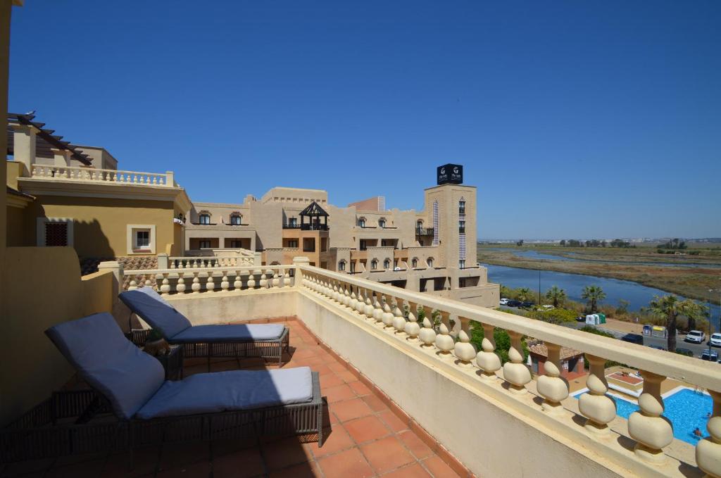 einen Balkon mit Stühlen und Flussblick in der Unterkunft Playa Canela PREMIUM & SOLMARES in Punta del moral