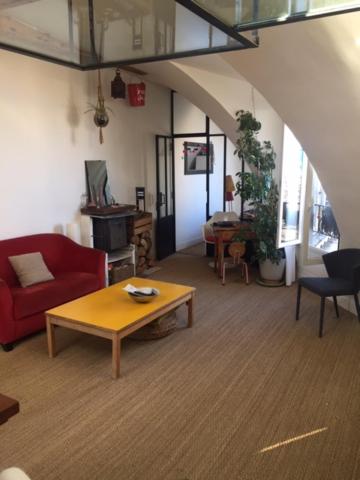 un salon avec un canapé rouge et une table basse dans l'établissement Location studio Paris 11, à Paris