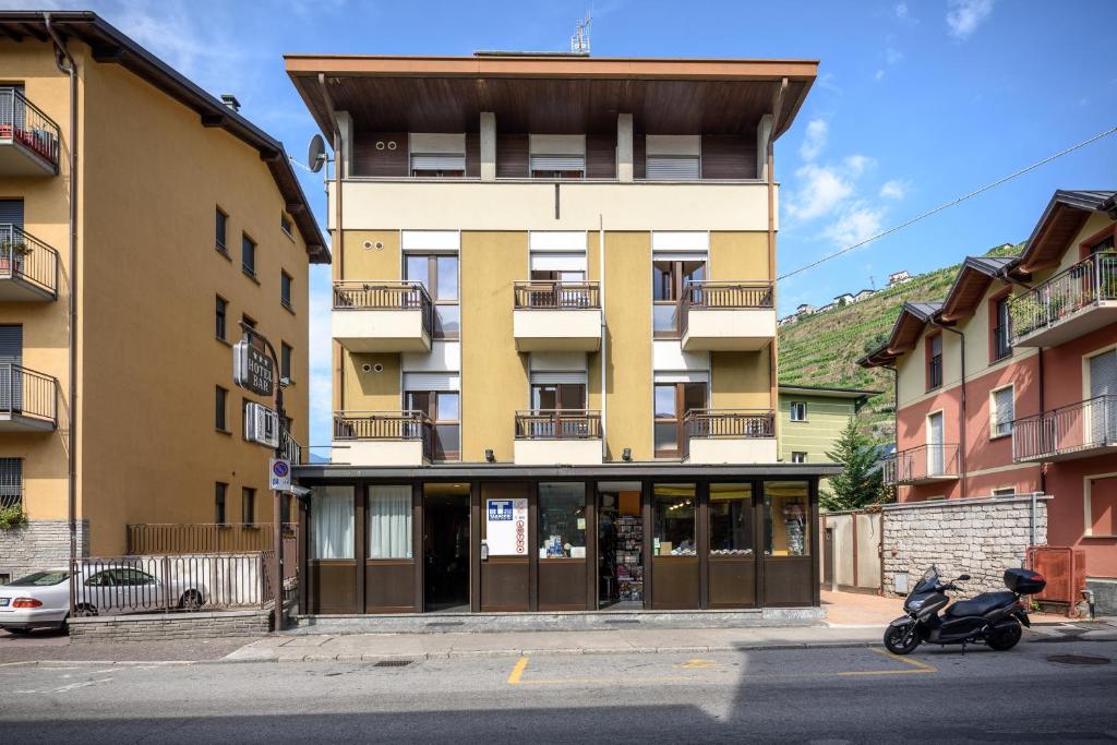 ein Gebäude mit einem Roller, der davor geparkt ist in der Unterkunft Hotel Schenatti in Sondrio