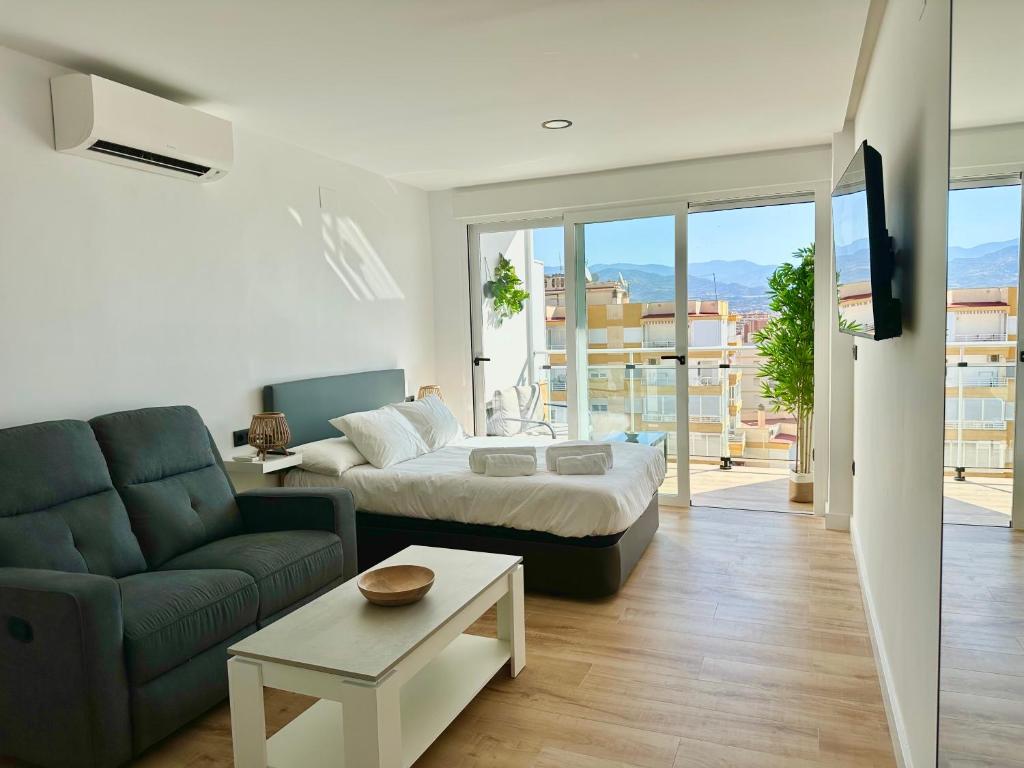 a living room with a bed and a couch at Apartamento Bambú in Torre del Mar