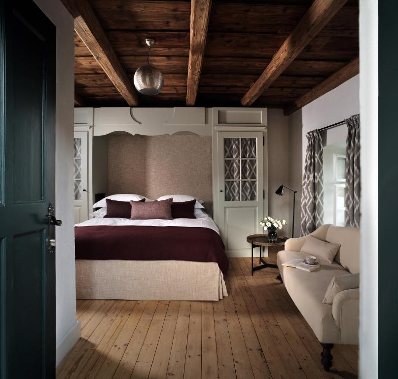 een slaapkamer met een groot bed en een bank bij Bethlen Estates Transylvania in Daneş