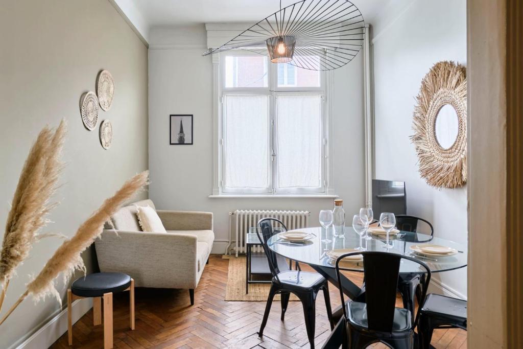 un salon avec une table, des chaises et un canapé dans l'établissement Appartement a proximité de Lille, à Marcq-en-Barœul