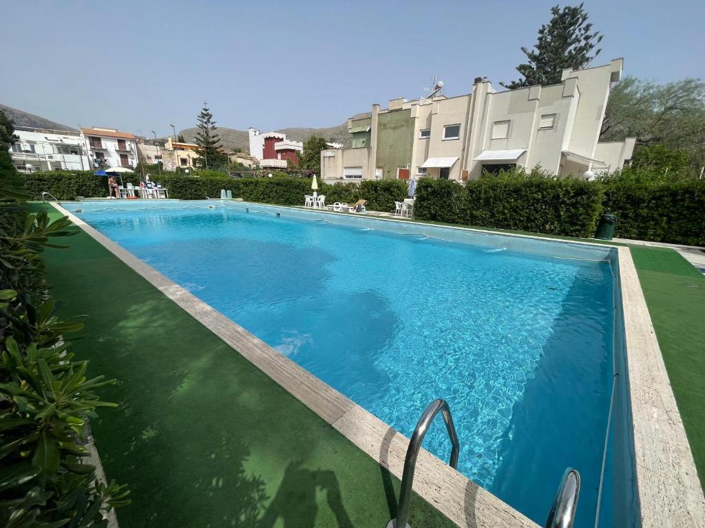 een groot blauw zwembad voor een gebouw bij Flat with Terrace & Pool in Mondello