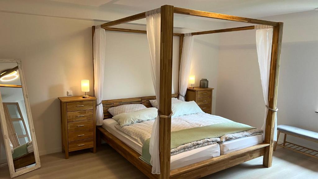 a bedroom with a canopy bed and a mirror at Kurpark Ferienwohnung in Schleiden