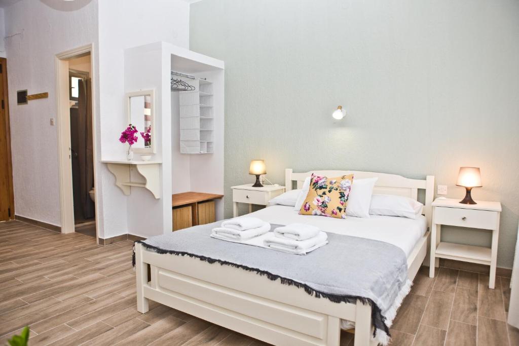a bedroom with a white bed with towels on it at Skalopati Studios & Villa in Panormos Skopelos