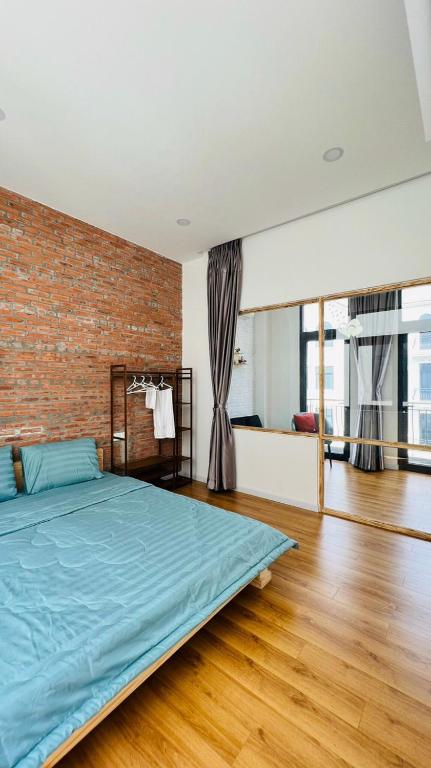 a bedroom with a bed and a brick wall at Happy House in Ho Chi Minh City