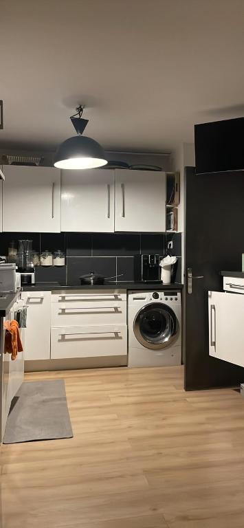 une cuisine avec des armoires blanches et une machine à laver dans l'établissement Chambre privée, à Aix-en-Provence