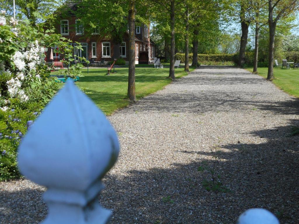 a path in a park with trees and a house at Ferienhof Bisdorf "Leuchtturm" in Bisdorf