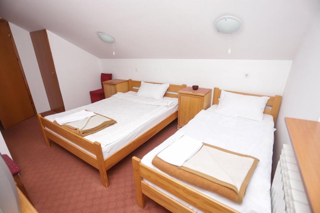 2 Betten in einem kleinen Zimmer mit in der Unterkunft Restora Točak Mokro Rooms in Mokro