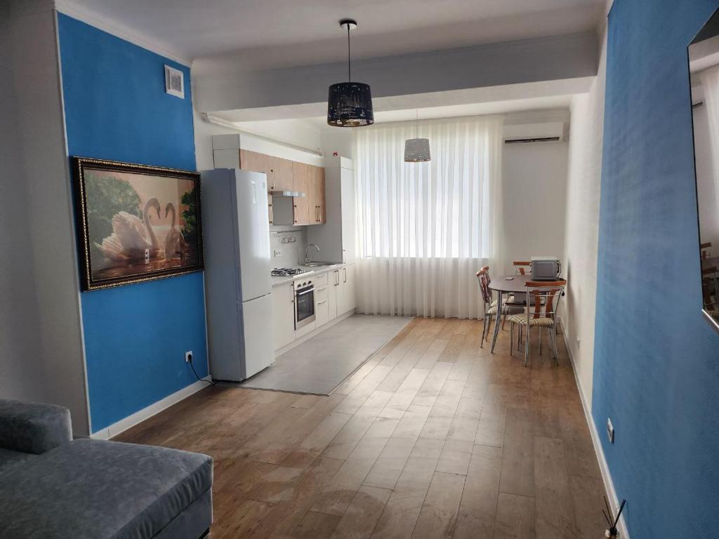 une cuisine avec une table et un mur bleu dans l'établissement Greenwich, à Tachkent