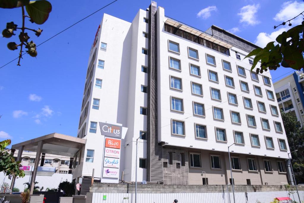 a white building with a sign in front of it at Citrus Classic Bengaluru in Bangalore