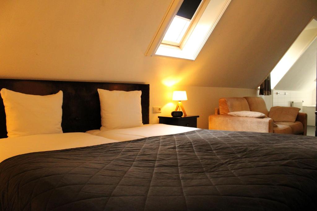 a bedroom with a large bed and a window at Havezathe Carpe Diem in Vethuizen