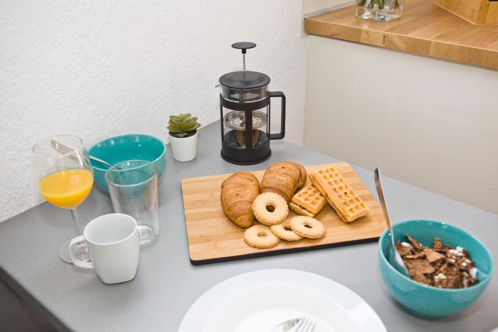 a table with a cutting board with bread and pastries at Skalopati Studios & Villa in Panormos Skopelos