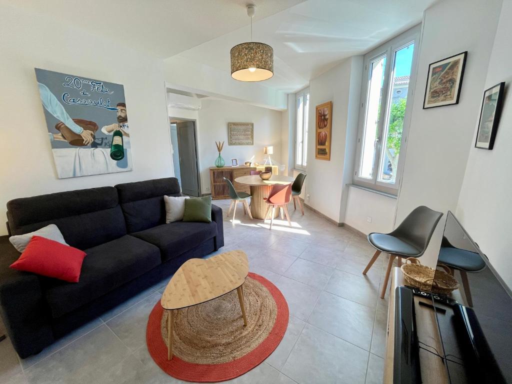 un salon avec un canapé et une table dans l'établissement Le chaurien - central et climatisé - local vélo, à Castelnaudary