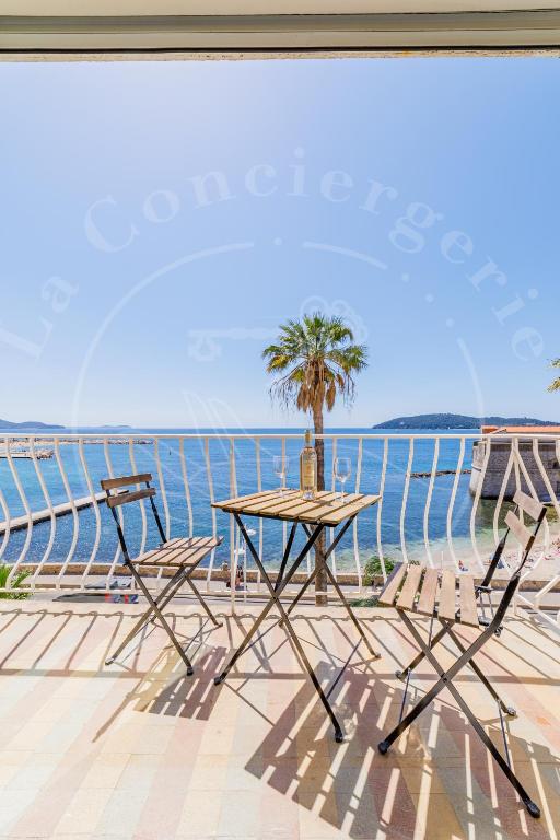 - une table et des chaises sur une terrasse donnant sur l'océan dans l'établissement Élégance Côtière - Vue imprenable, Plage à 5 min, à Toulon