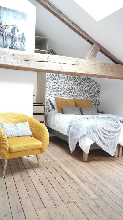 a bedroom with a bed and a yellow chair at La Galerie, Et Pop Et Chic ! in Poitiers