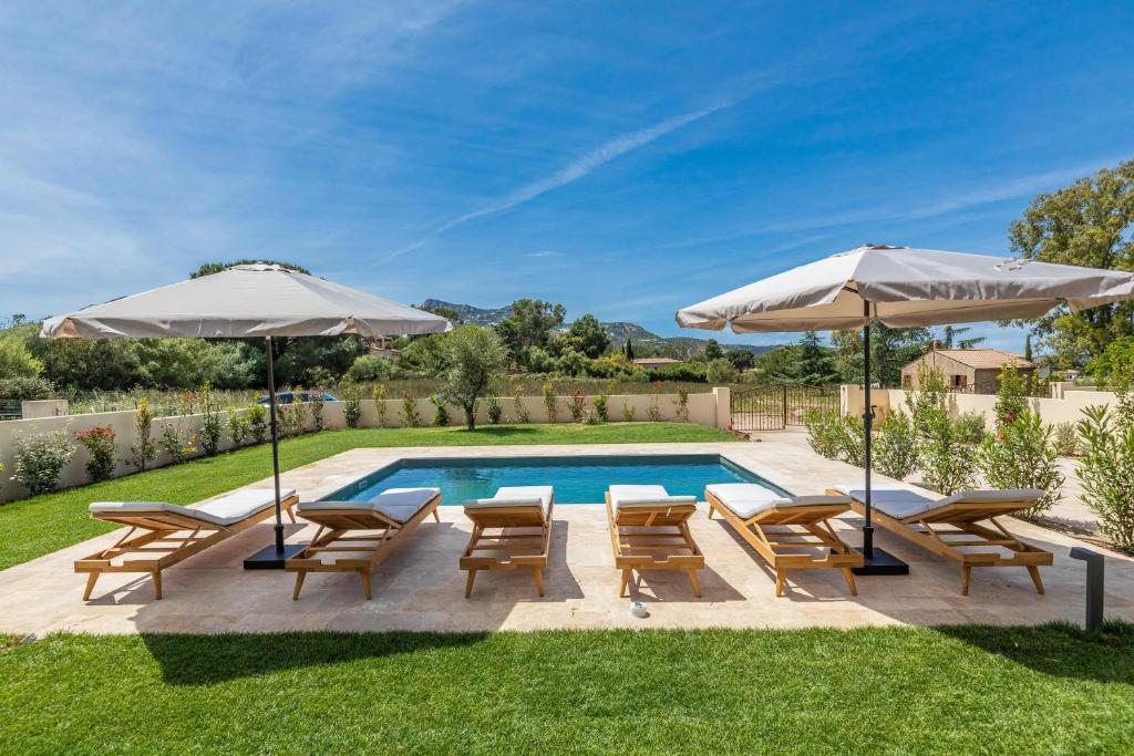 une piscine avec des chaises et des parasols à côté d'une piscine dans l'établissement Résidence Casaviva, à Calvi