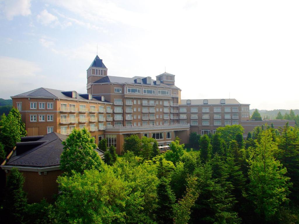 ein großes Gebäude mit einem Turm auf Bäumen in der Unterkunft Sendai Royal Park Hotel in Sendai