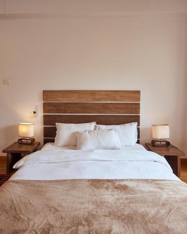 a bedroom with a large bed with two lamps at Ananya Apartments Phase 1 in Kathmandu