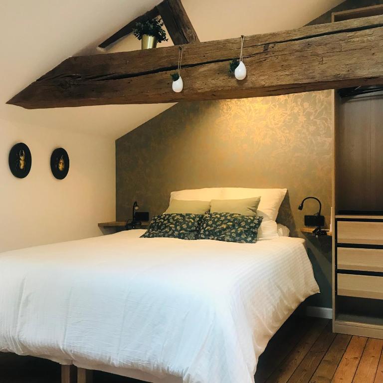 - une chambre avec un lit blanc et un plafond en bois dans l'établissement La Curiosité, Et Pop Et Chic !, à Poitiers