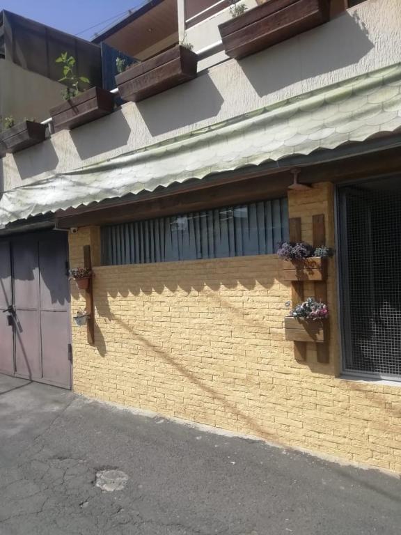 a yellow brick building with a window and flower boxes at Anahit in Yerevan