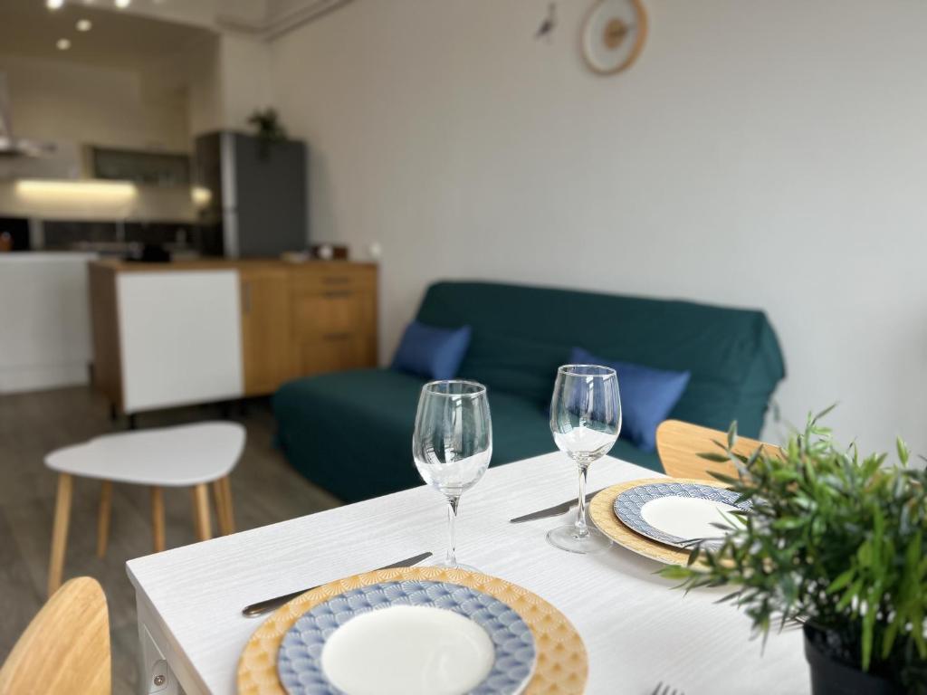 une table avec deux verres à vin et des assiettes dessus dans l'établissement La Mouette, à Calais