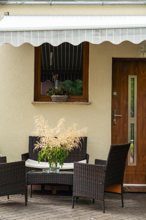 a patio with a table and chairs and a window at Apartament Londyn in Łagów