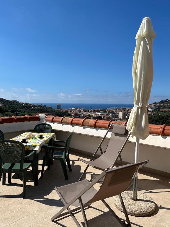 a patio with a table and chairs and an umbrella at T V B - Vacanze Imperia in Imperia
