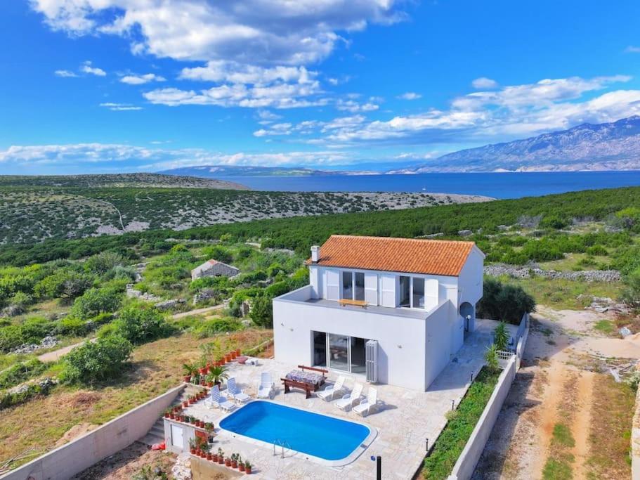 Una vista aérea de una casa blanca con piscina. en Villa Joanna - hidden oasis with pool, gym & garrage, en Novalja