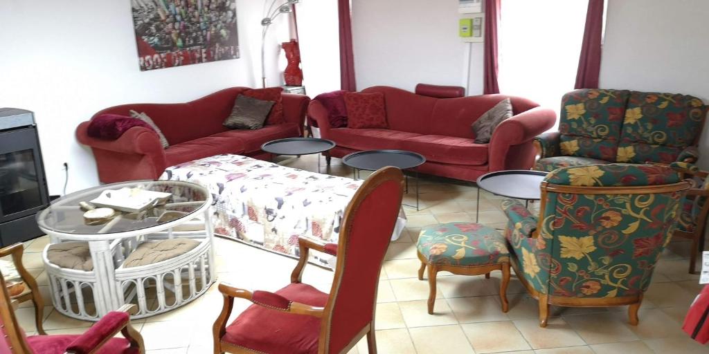 - un salon avec des canapés et des chaises rouges dans l'établissement Welcome to Cogners, à Cogners