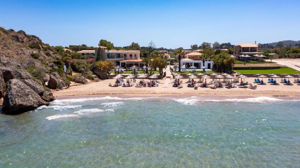 una vista di una spiaggia con sedie e un resort di Plaka Beach Resort a Vasilikós