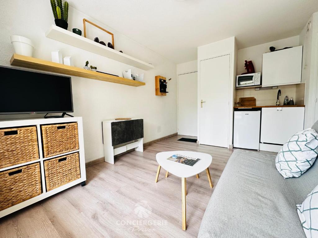 un salon avec une télévision à écran plat et une table dans l'établissement Le Sable d'Or - Appartement coeur de ville, à Saint-Palais-sur-Mer