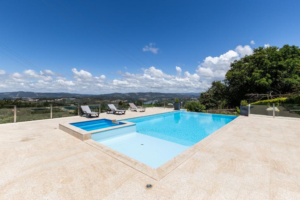 a swimming pool with two lounge chairs next to it at Crestuma Bright Apartment, by Hopstays in Crestuma