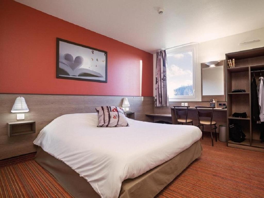Saint-Barthélemy-dʼAnjou的住宿－昂熱王牌酒店，一间卧室设有一张大床和红色的墙壁